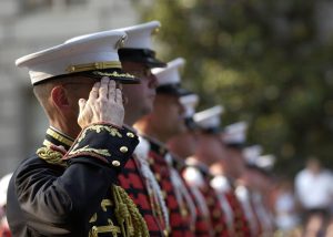 Hombres con traje militar negro y amarillo haciendo cola durante el día